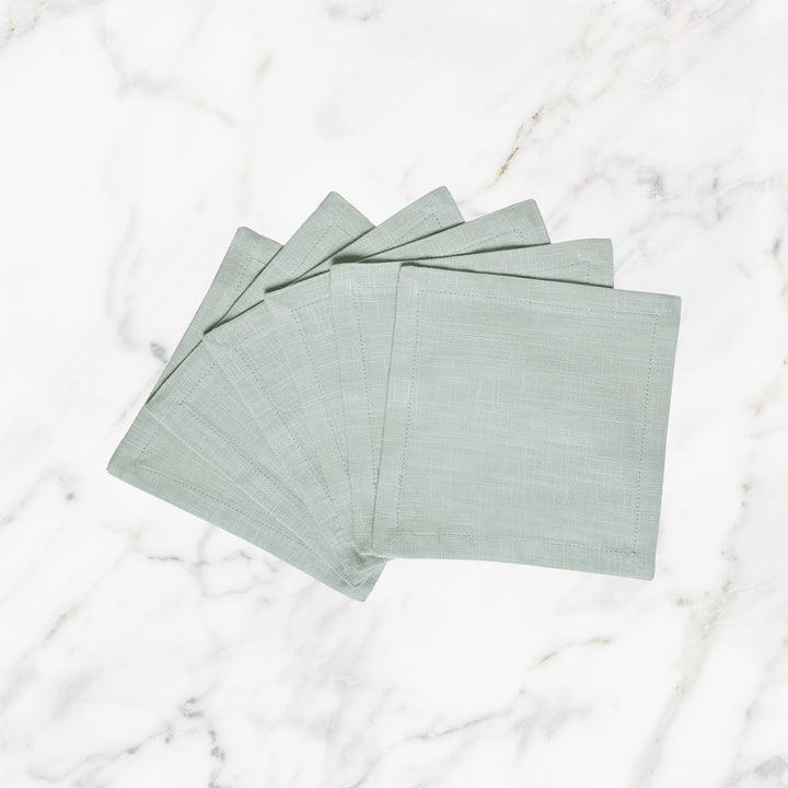 CNP-4906-66_1|Elegant set of light green linen fabric dinner napkins, fanned on a luxurious white marble background, perfect for entertaining.