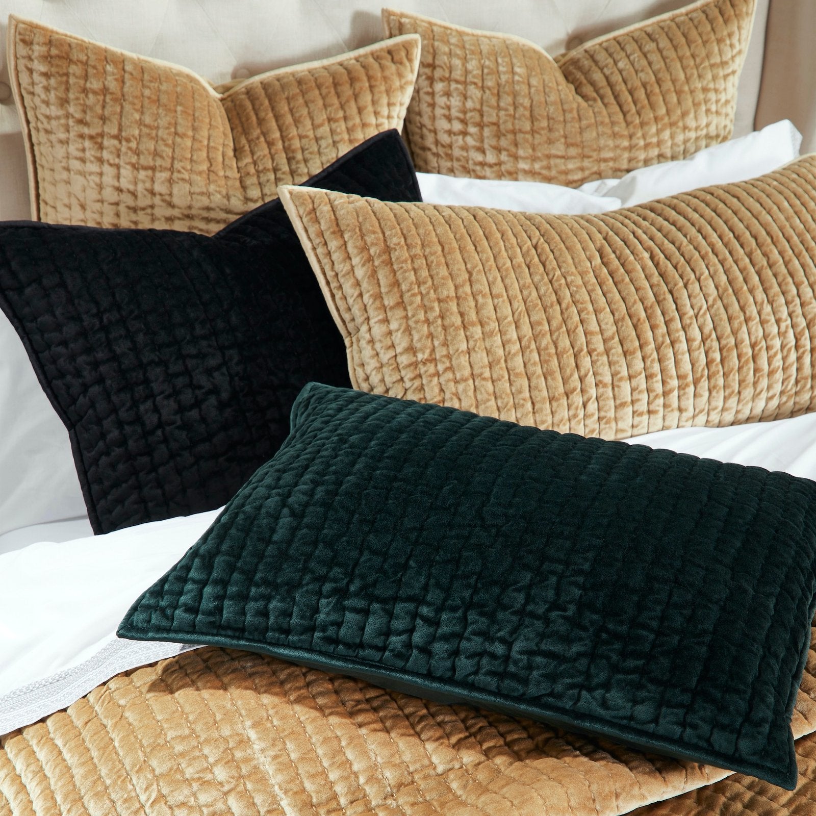 SS-340-DUP-X_2|Assorted luxurious velvet quilted pillows in gold, black, and emerald green, creating a rich, inviting bed ensemble with texture.