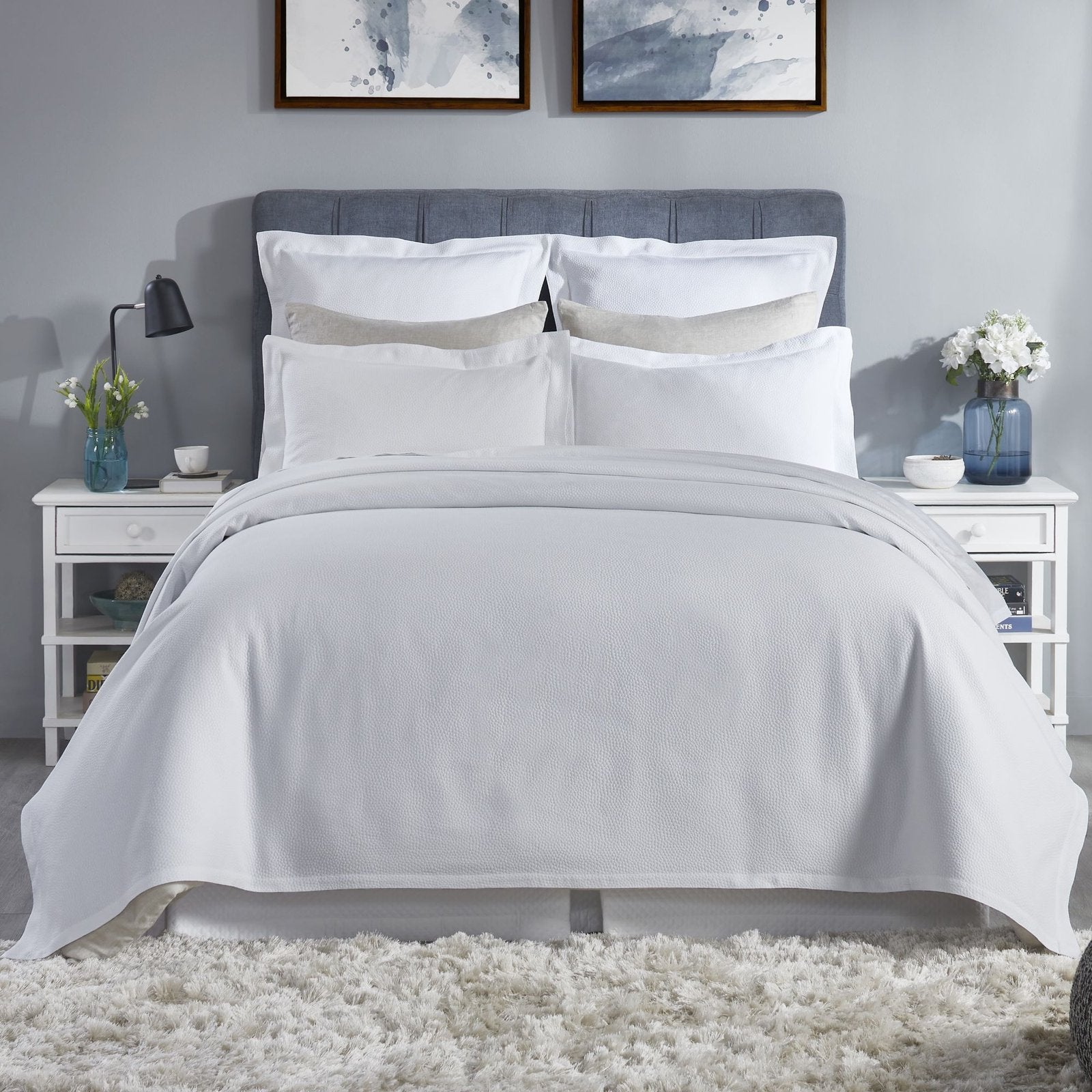 CL-258-X_1|Crisp white textured coverlet beautifully drapes over a bed, offering a clean, contemporary look and refreshing bedroom style.