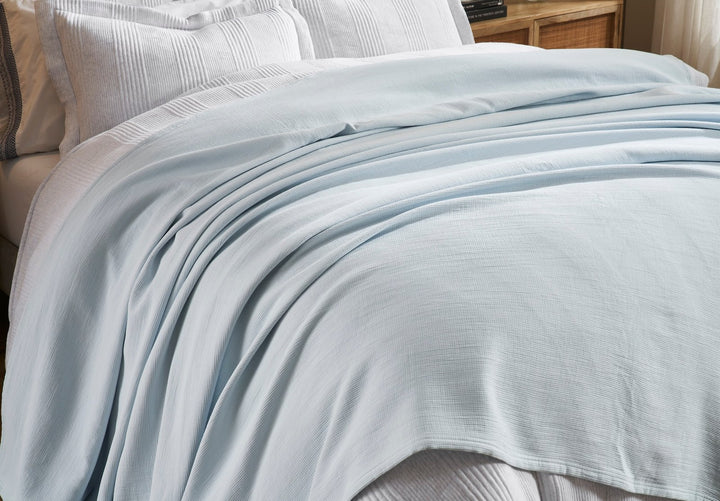 BL-859-9496_3|Detailed view of a light blue waffle weave blanket gracefully spread over a pristine white bed. Cozy, stylish, breathable.