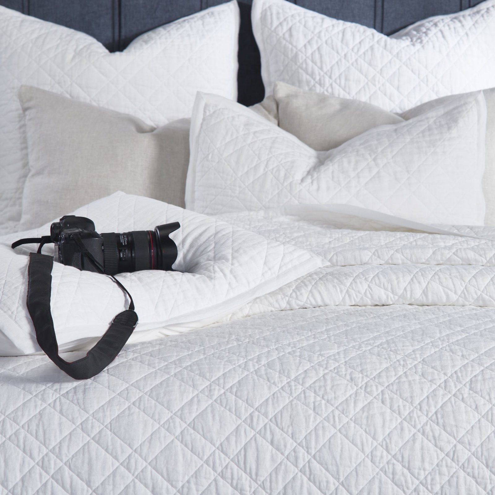 CL-253-11096_4|Intimate close-up of a crisp white quilted coverlet, emphasizing its soft, intricate texture for luxurious bedroom bedding.