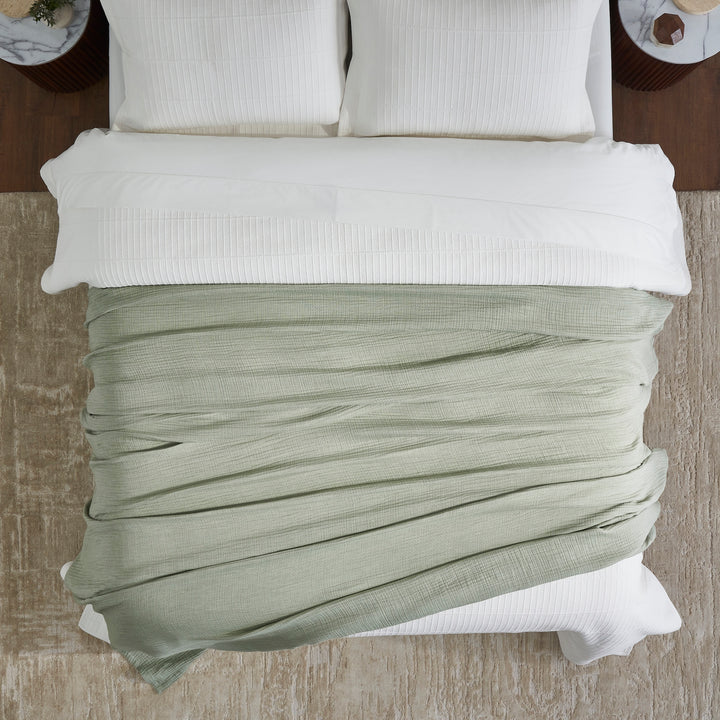 BL-864-11096_4|Soft, sage green textured blanket on a neatly made bed, offering a cozy and inviting look from a top-down view.