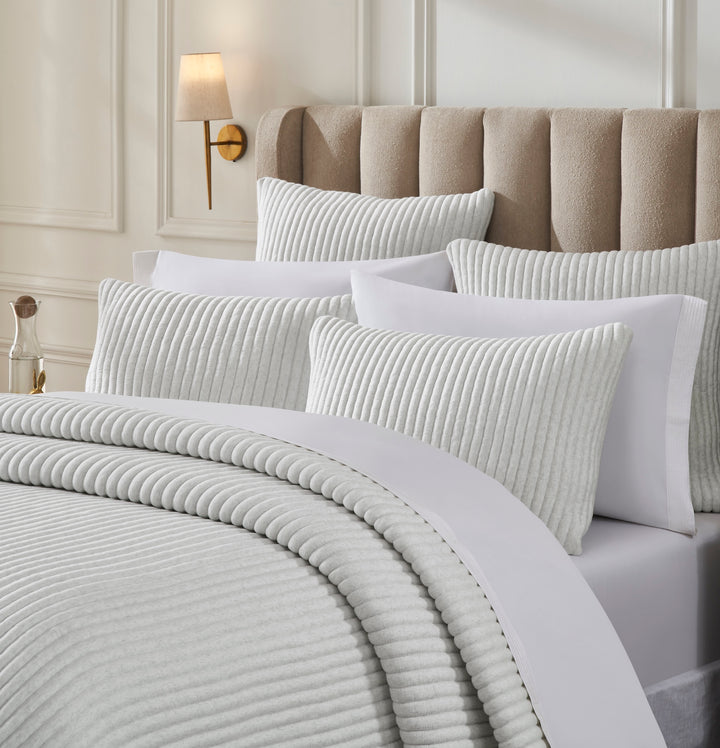 QT-374-11096_3|Close-up of soft light grey ribbed quilt and pillows, highlighting the elegant bedding for a serene and comfortable bedroom.