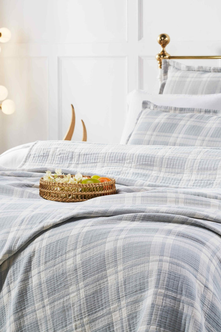 BT-117-9496_4|Close-up of a light blue and white plaid textured cotton blanket on a bed, showcasing the soft fabric and pattern detail.