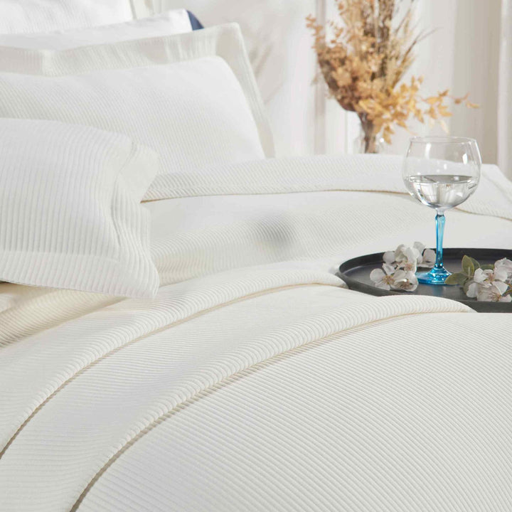 CL-192-11096_4|Soft white striped coverlet detailed on a bed, offering a luxurious and inviting texture for premium hotel-quality bedding.