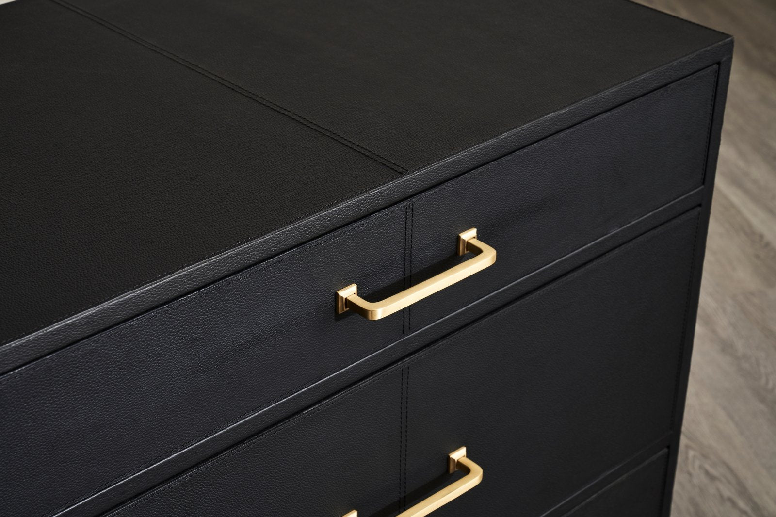 FN-5200-262028_7|Elegant black leather-wrapped nightstand featuring modern design, three drawers, and stunning gold pull handles.
