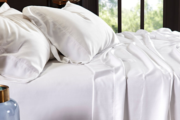 CSS-509-7284_3|Close-up of white 100% Lyocell sheet set on a bed. Visible flat sheet and pillowcases with sateen weave.