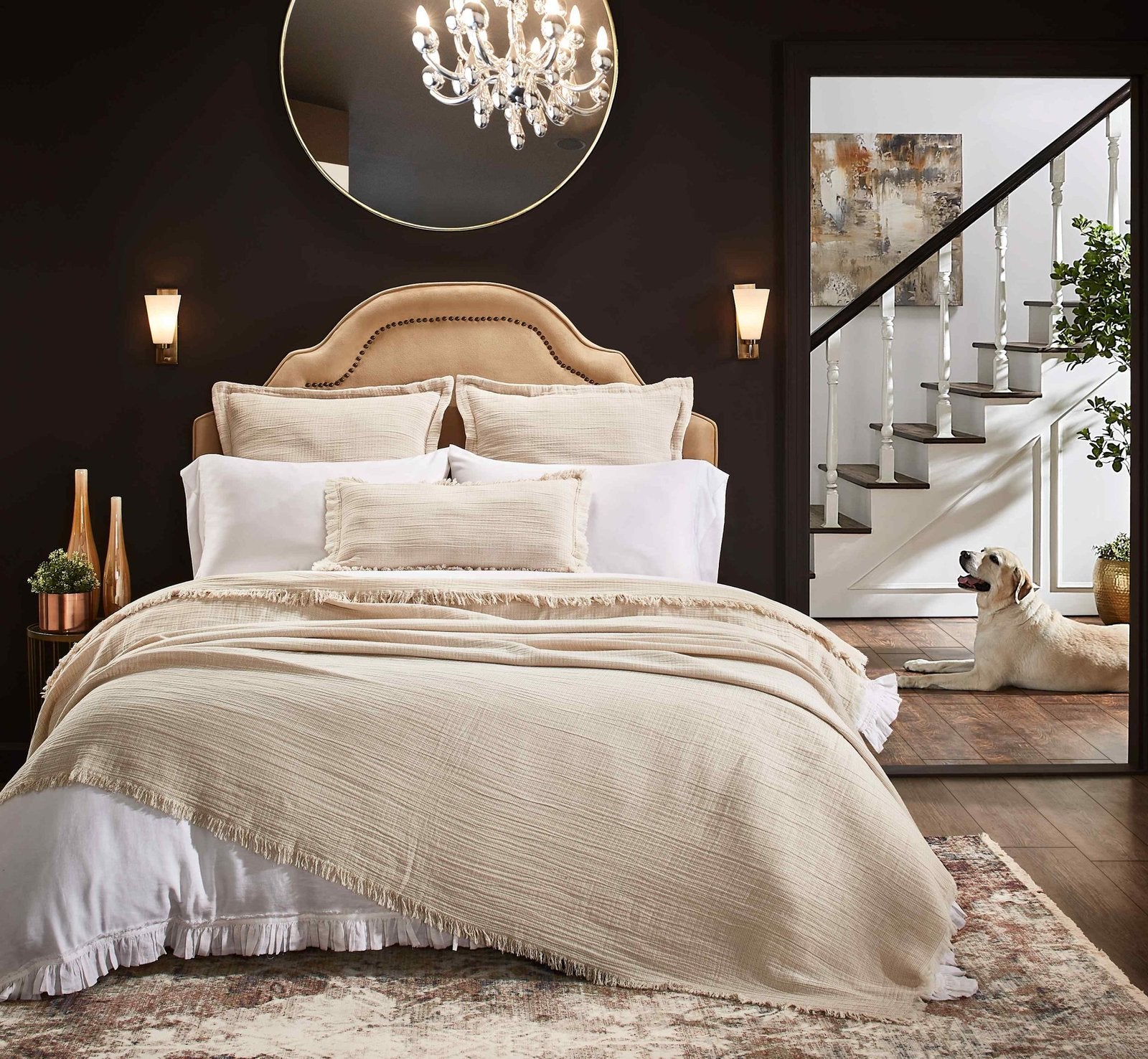 BT-115-9496_6|Inviting bedroom with a cream fringed blanket on a large bed. Neutral decor, warm lighting, and wood elements.
