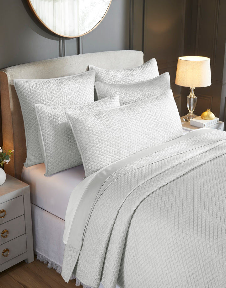 CL-266-11096_3|Close-up of light gray diamond quilted coverlet and matching pillows, showcasing intricate patterns. Luxurious, soft bedding ensemble.