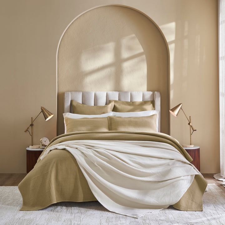 CL-269-9496_6|Elegant tan ribbed coverlet adorning a stylish bedroom bed, partially draped with a soft white throw, enhancing a warm aesthetic.