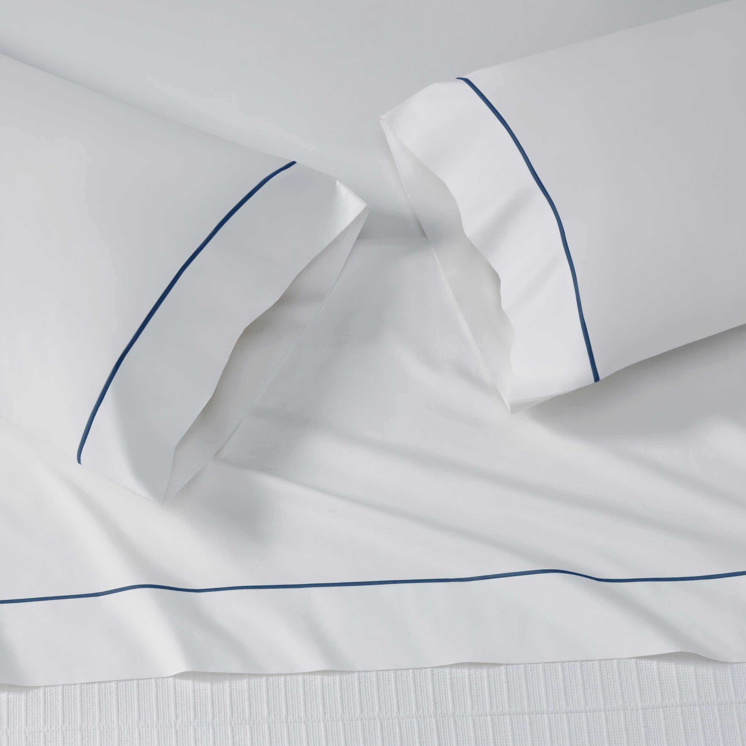 AKP-549-2040_4|Crisp 100% cotton sheets in pure white, featuring elegant navy blue piped borders for a classic, cool look.