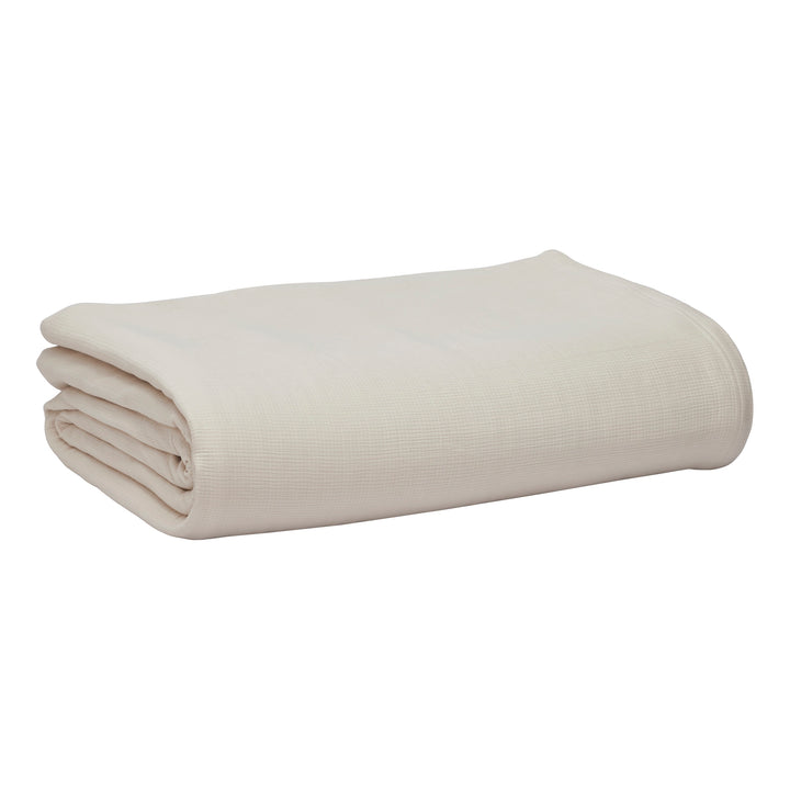 BL-860-11096_7|Tidily folded cream waffle weave blanket, offering comforting warmth and elegant texture for your bed or sofa. Versatile.