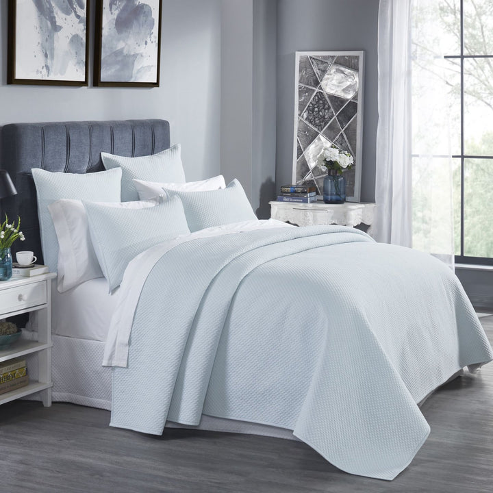 CL-251-11096_2|Light blue textured coverlet elegantly drapes a queen bed, enhancing a bright room with a peaceful ambiance.