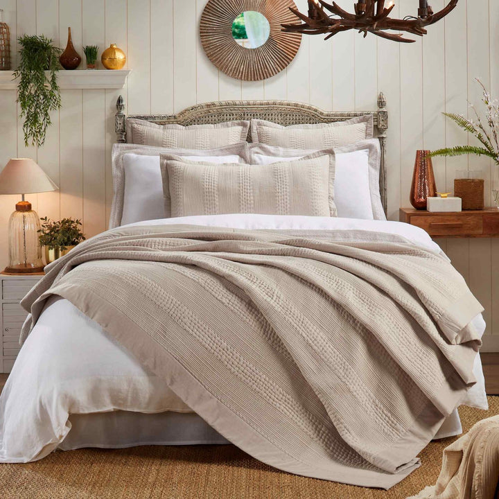 CL-164-11096_1|Neutral beige textured coverlet draped over a white bed in a cozy bedroom, adding warmth and sophisticated style.