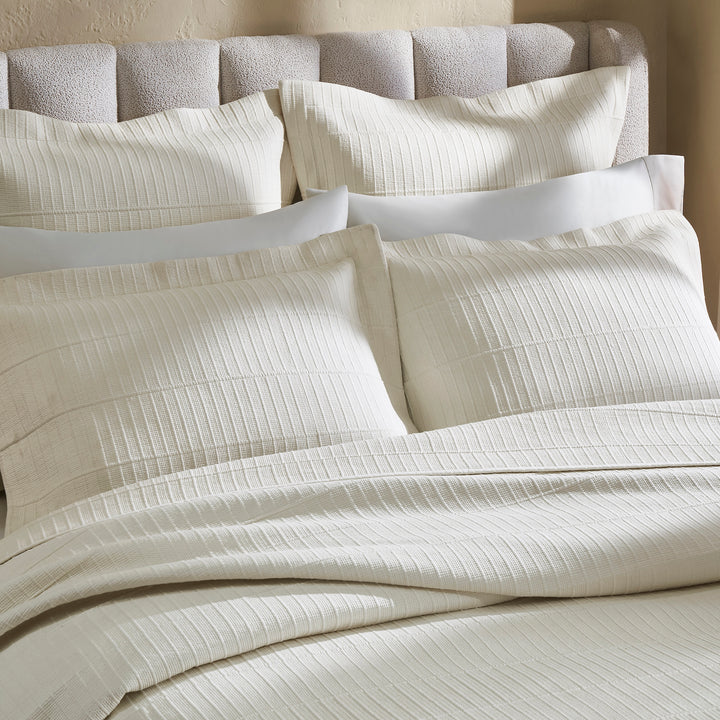 CL-271-11096_9|Cream textured coverlet and matching shams on a cozy bed, featuring a ribbed pattern, perfect for luxurious bedding.