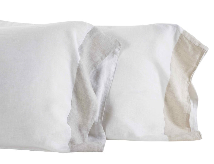 ASP-517-X_2|Pair of crisp white linen pillow shams with natural tan accents, offering a sophisticated and comfortable bedding option.