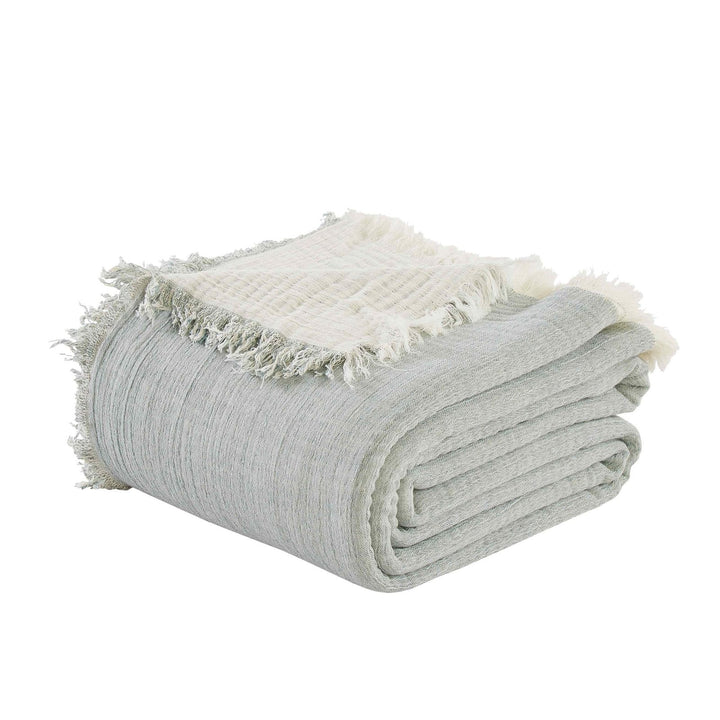 BT-109-9496_2|Folded light blue crinkled blanket with frayed edges, revealing its soft texture and reversible design for relaxed home comfort.