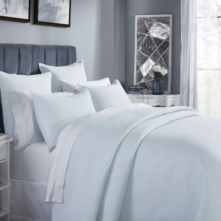 CL-251-11096_3|Close-up of a beautifully arranged light blue textured coverlet on a queen bed, showcasing its soft, inviting feel.