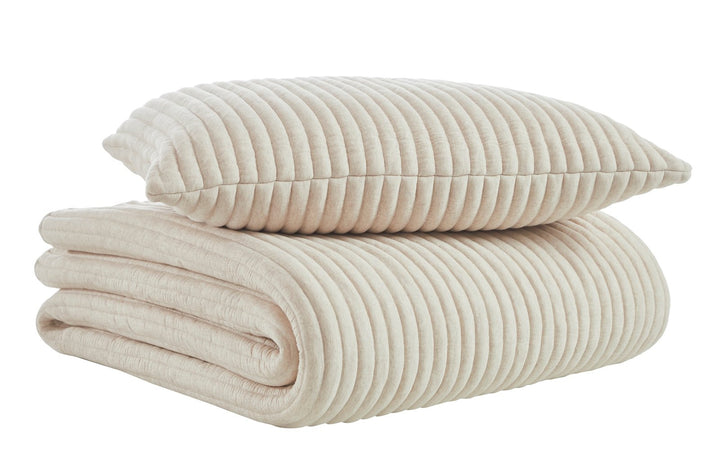 QT-368-11096_6|Folded beige ribbed quilted quilt and matching pillow, showcasing the uniform, cozy texture and striped design.