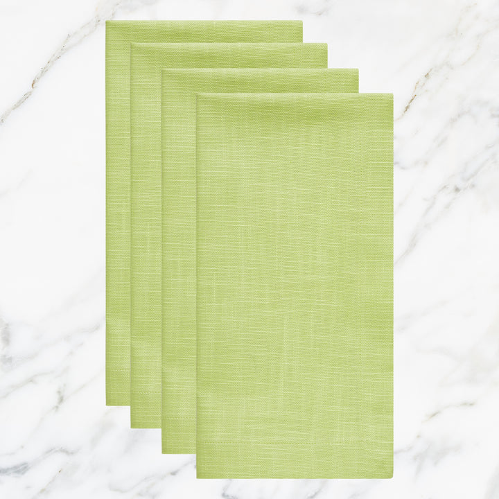NP-4804-2020_1|Four folded lime green cloth dinner napkins on marble background. Vibrant reusable fabric napkins for spring, summer events.