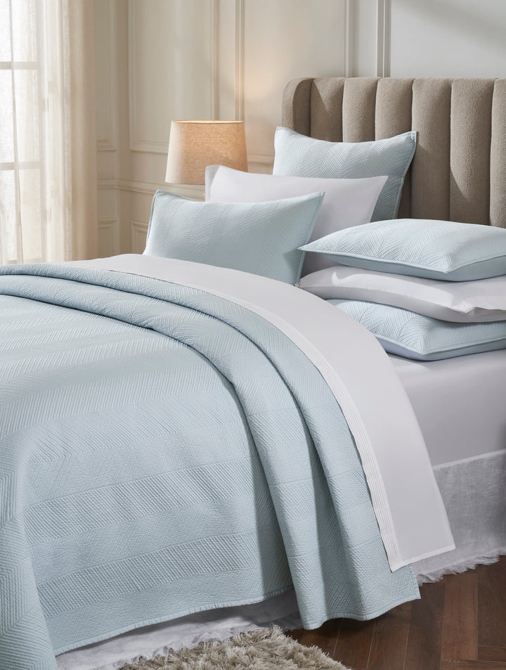 CL-262-9496_3|Detailed view of a light blue quilted coverlet set, showcasing its stylish herringbone pattern and soft texture on a bed.
