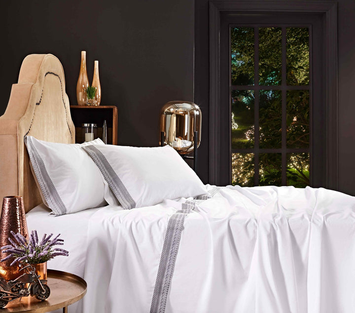 QSS-502-6080_3|White 100% cotton sheets with elegant decorative trim, draped neatly on a bed, offering soft, breathable comfort.