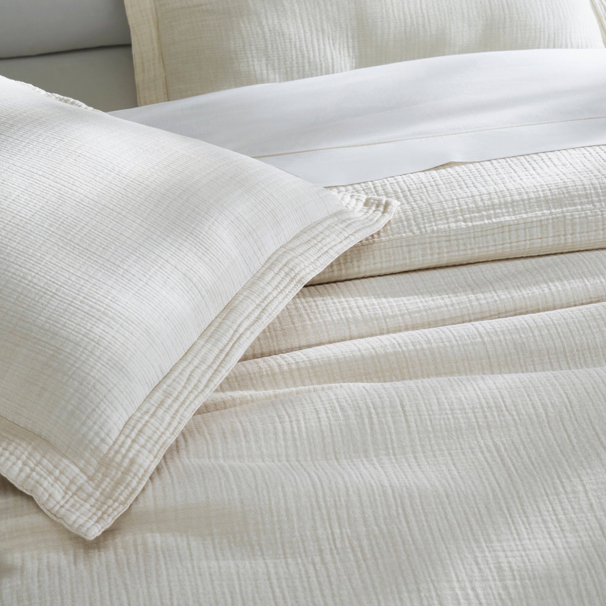 DT-049-10692_6|Close-up of a soft light cream textured organic cotton gauze duvet cover and matching pillow sham, highlighting comfort.