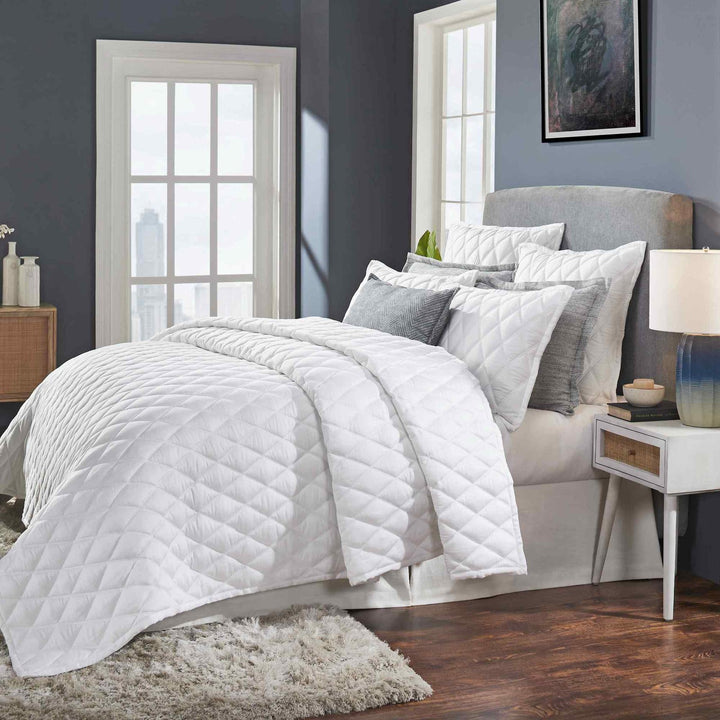 CL-179-9496_2|White quilted coverlet draped on modern bed, showcasing diamond pattern, enhancing contemporary bedroom decor.