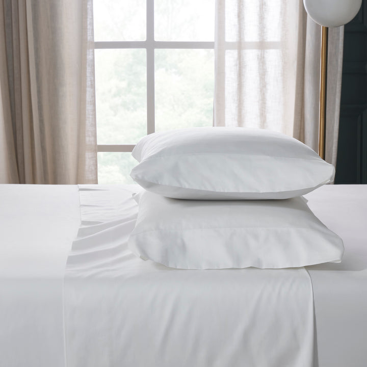 KSS-547-7880_2|Crisp white 100% cotton sheets and soft pillowcases neatly stacked on a bed, highlighting premium quality bedding.