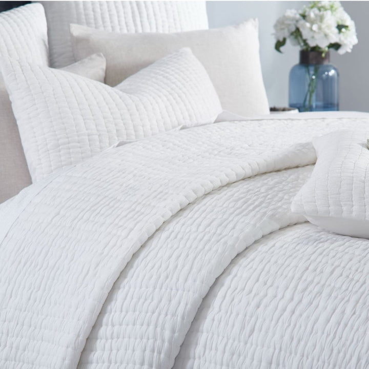 QT-359-9496-LOT1_4|Close-up of a soft white quilted cotton bedspread, showcasing its subtle textured pattern and cozy, inviting appeal.